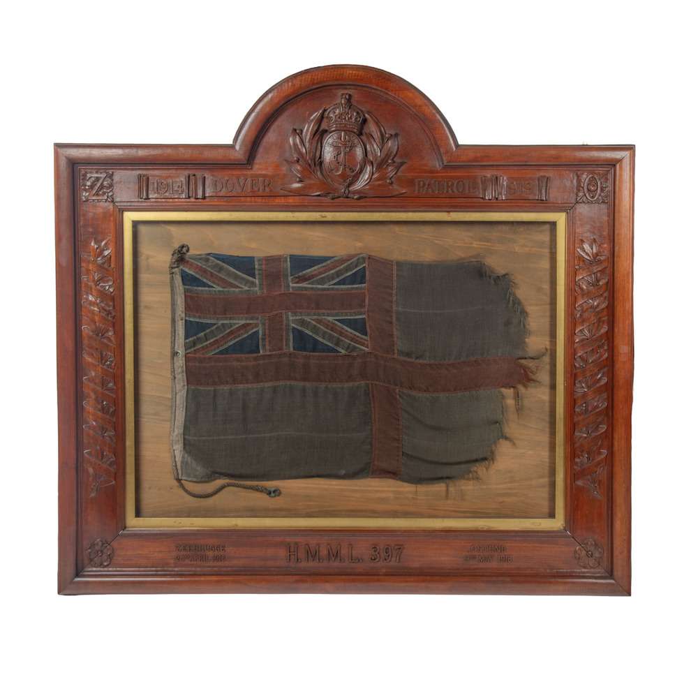 The smoke-stained White Ensign from Motor Launch 397, dated 1918, displayed in its carved teak frame. Photography courtesy of Wick Antiques.